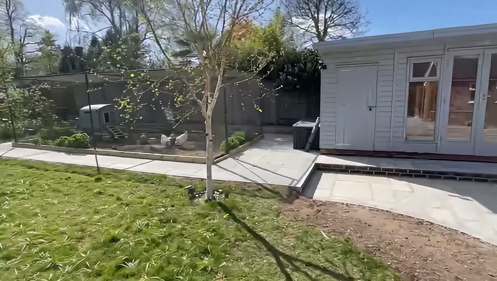 A finished Family Tree job — sandstone patio, stepping stones set into gravel and a new garden room